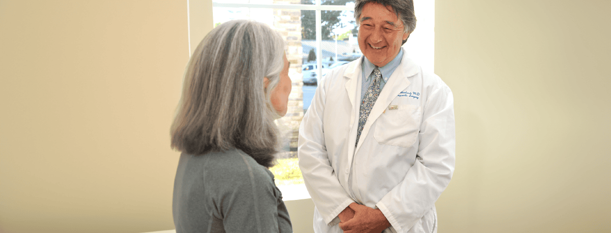 Doctor smiling at a patient in an exam room.