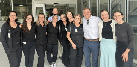 A group of people standing in front of a medical office building.