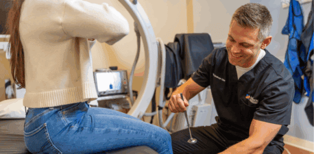 Doctor performing an ortho exam in an exam room.
