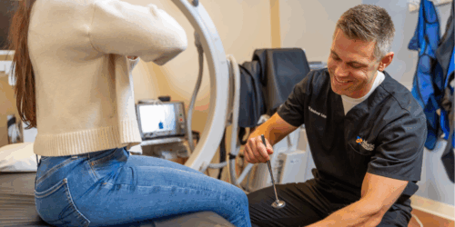 Doctor performing an ortho exam in an exam room.