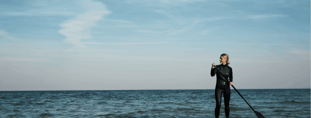 woman on a stand up paddle board on the ocean.