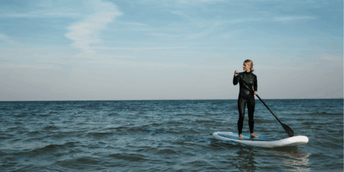 woman on a stand up paddle board on the ocean.